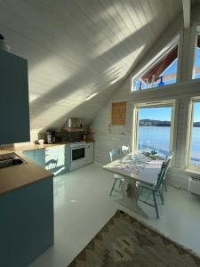 a kitchen with a table and chairs in a room at Cabin by the lake in Sveio