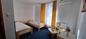 a small room with two beds and a window at Vila Casa Alesiv in Cluj-Napoca