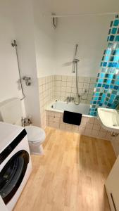 a bathroom with a tub and a toilet and a sink at Apartment Osnabrück Haste in Osnabrück