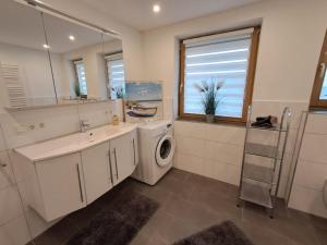 a bathroom with a washing machine and a sink at Im Idyll 3 in Hengersberg +34 photos