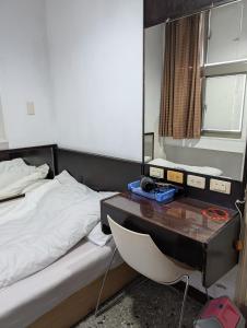 a bedroom with a bed with a desk and a bed sidx sidx sidx at Golden Dragon Hotel in Houlong +16 photos