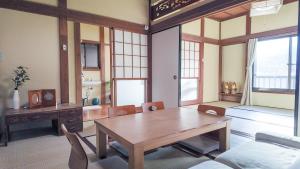 a living room with a wooden table and chairs at FUNAKATA MINA House in Tateyama