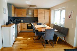 a kitchen with a wooden table and chairs in a kitchen at Ferienhaus DONAUzeit in Sigmaringen
