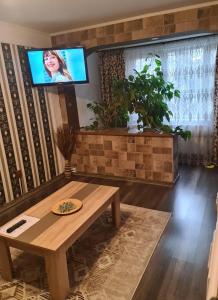 a living room with a table and a tv on a wall at Casa & Julieta in Tecuci +7 photos