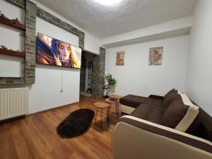 a living room with a couch and a flat screen tv at NeNa Apartmani - Ruma in Ruma