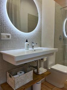 a bathroom with a sink and a toilet and a mirror at Villa Martí in Calpe