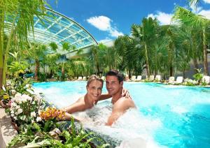 a man and woman in a swimming pool at a resort at Best Western Hotel am Europaplatz in Königsbrunn