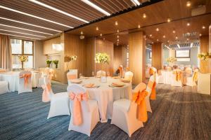 ein Festsaal mit weißen Tischen und weißen Stühlen in der Unterkunft Rosslyn Central Park Hotel Sofia in Sofia