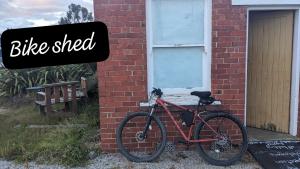 a bike parked in front of a brick building at Ranfurly Hostel with Sauna in Ranfurly