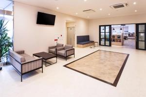 a lobby with couches and a tv on a wall at Comfort Hotel Kochi in Kochi