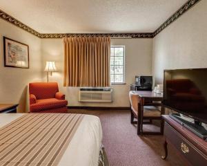 a hotel room with a bed a desk and a television at Econo Lodge Inn & Suites El Paso West in El Paso