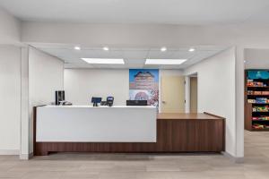 an office lobby with a white counter and a pharmacy at Clarion Pointe I-85 High Point - Archdale in Westwood
