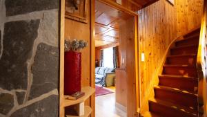a room with a staircase and a red vase at Rustico Pagrüeg - Swiss Alpine Charm 1-5 Pers in Klosters Serneus