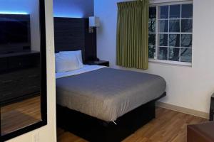 a bedroom with a bed and a large window at Quality Inn Fishers - Indianapolis in Fishers