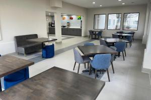 a waiting room with tables and chairs in a restaurant at Quality Inn Fishers - Indianapolis in Fishers