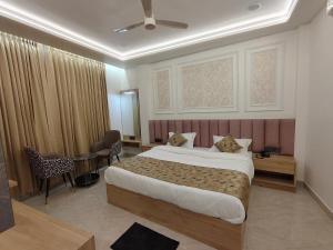a hotel room with a bed and a table and chairs at Baba Palace in Ayodhya