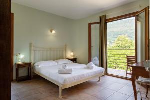 a bedroom with a bed and a sliding glass door at Pargadise Aprtments in Parga