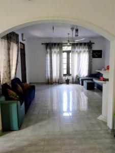 a large living room with couches and a large window at Oshi villa in Hikkaduwa