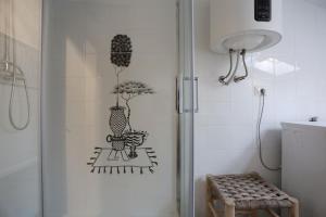 a bathroom with a shower with a drawing on the wall at mansarda fronte mare in Potenza Picena +17 photos