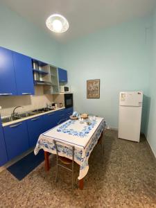 a kitchen with a table and a white refrigerator at In pieno centro in Crotone