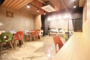 a restaurant with colorful chairs and tables in a room at Daegu Play and Stay Hotel in Daegu