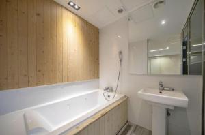 a bathroom with a sink and a tub and a mirror at Daegu Play and Stay Hotel in Daegu +31 photos