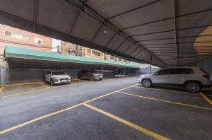 a parking lot with three cars parked in it at Daegu Play and Stay Hotel in Daegu