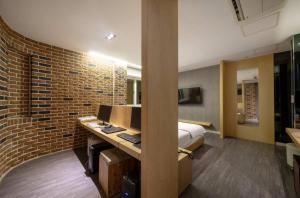 a bedroom with a bed and a desk with a computer at Daegu Play and Stay Hotel in Daegu