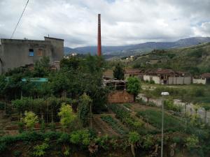 un vecchio edificio con una fabbrica sullo sfondo di La ViaRoma a Torre deʼ Passeri