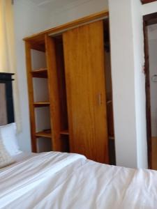 a bedroom with a bed and a wooden closet at Belaire BnB Ruaka 1 in Nairobi +6 photos