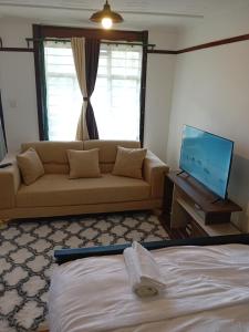 a living room with a couch and a flat screen tv at Belaire BnB Ruaka 1 in Nairobi