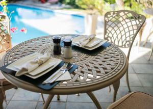 a table with plates and utensils on it next to a pool at De Wingerd Wijnland Lodge in Paarl