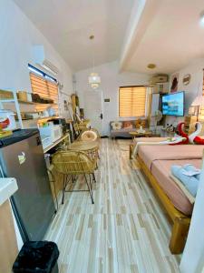 a bedroom with a bed and a desk and a living room at Olango Island - S&E-1 Tiny Guest House Fully Furnished with Hot Shower, Washer, Wi-Fi, Netflix & King-size Bed in Lapu Lapu City +13 photos