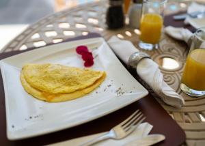 a plate with a pancake on a table with orange juice at De Wingerd Wijnland Lodge in Paarl