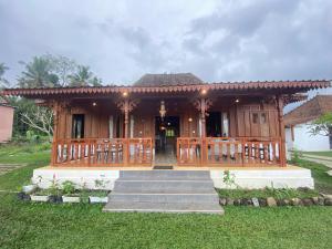 a wooden house with a porch and stairs to it at Sembung Healing House in Sangeh