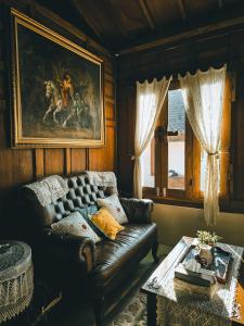 a living room with a leather couch and a table at Sembung Healing House in Sangeh