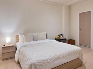 a bedroom with a large bed with a white comforter at Quies Hotel in Krabi