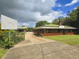 a building with a sign in front of it at Curtain Fig Motel in Yungaburra