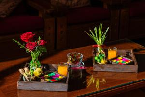 a table with two vases with flowers and drinks on it at Thanh Lich Hue Hotel in Hue