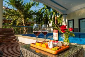 a tray of food and two glasses of wine on a table at Thanh Lich Hue Hotel in Hue +48 photos