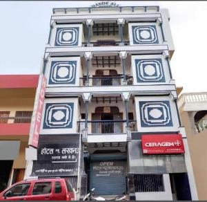 a building with a red car parked in front of it at Hotel New Lucknow in Lucknow