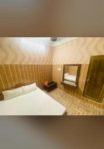 a small bedroom with a bed and a mirror at Hotel New Lucknow in Lucknow +3 photos