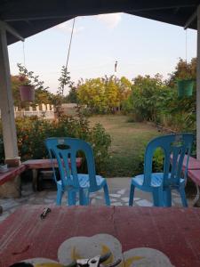 two blue chairs sitting on a patio with a table at CC Homestay in Surin +9 photos
