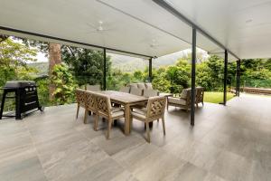 a dining room with a table and chairs at Rainforest Escape with Pool & Mountain Views in Caravonica