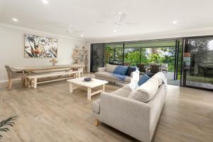 a living room with a couch and a table at Rainforest Escape with Pool & Mountain Views in Caravonica