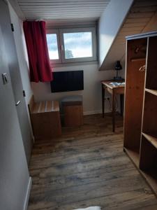 an attic room with a television and a desk at hotel le malgovert SEEZ 73 in Séez