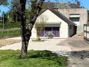 a white garage with a tree in front of it at Gîte de Bonabry in Guipry-Messac