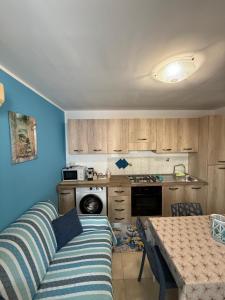 a living room with a couch and a table in a kitchen at Bilocale zona spiaggia Home Salento com in Torre San Giovanni Ugento