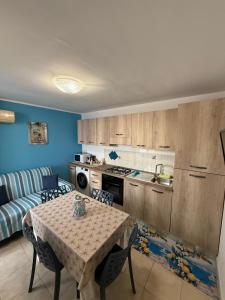 a kitchen with a table and a living room at Bilocale zona spiaggia Home Salento com in Torre San Giovanni Ugento
