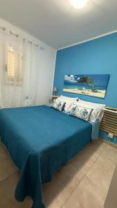 a blue bedroom with a bed with a blue wall at Bilocale zona spiaggia Home Salento com in Torre San Giovanni Ugento